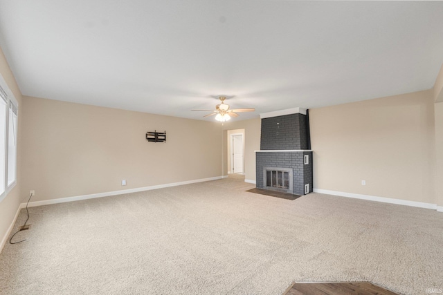 unfurnished living room with a fireplace, carpet floors, and ceiling fan