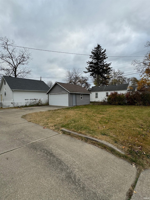 view of front of property with a front yard, a garage, and an outdoor structure