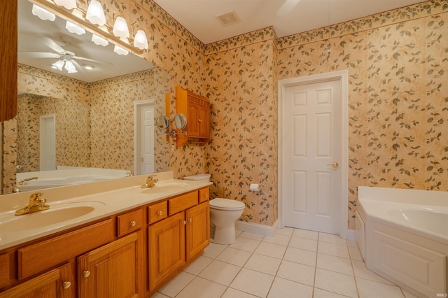 bathroom with tile patterned floors, a washtub, vanity, ceiling fan, and toilet