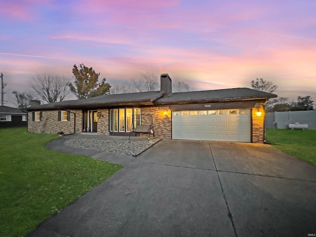 view of front of property with a garage and a yard