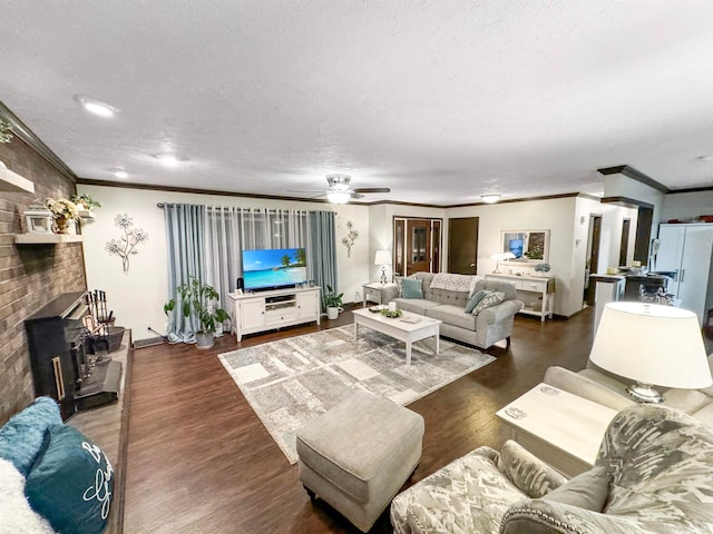 living room with a textured ceiling, dark hardwood / wood-style flooring, ceiling fan, and crown molding