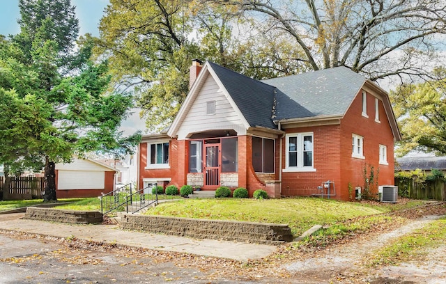 bungalow featuring central AC unit and a front yard