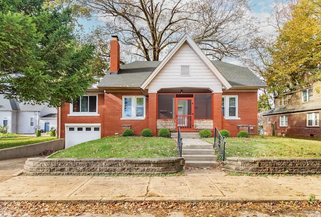 bungalow with a front yard, a garage, and a sunroom