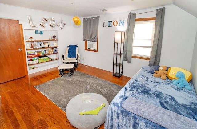 bedroom featuring cooling unit, wood-type flooring, and lofted ceiling