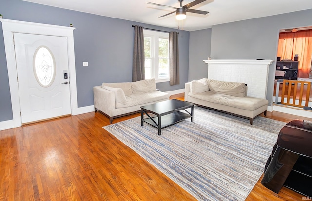 living room featuring ceiling fan and hardwood / wood-style floors