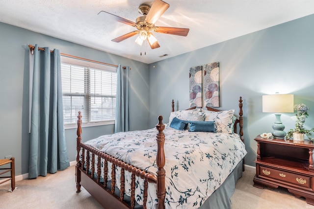 bedroom featuring light carpet, a textured ceiling, and ceiling fan