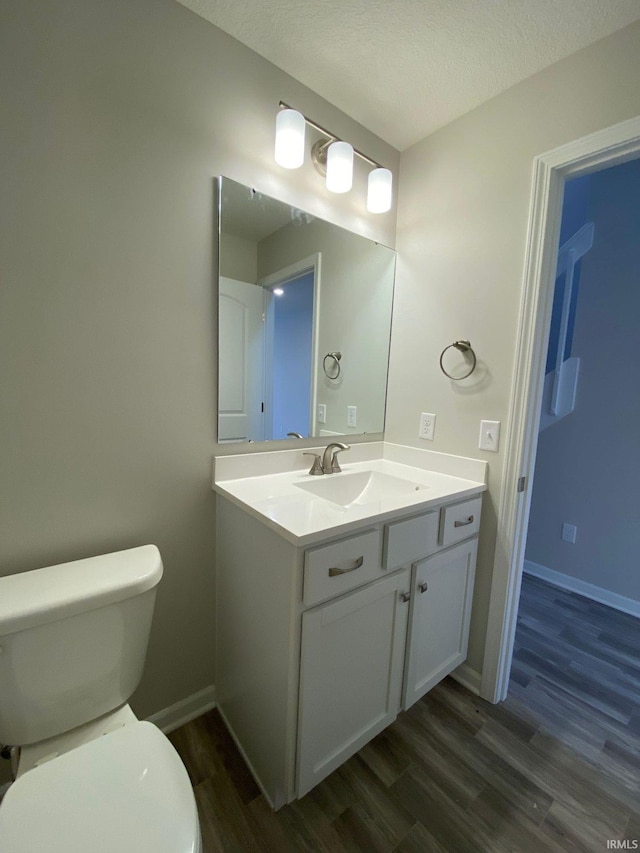 bathroom featuring hardwood / wood-style floors, vanity, a textured ceiling, and toilet