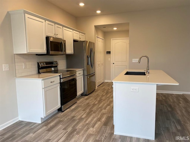 kitchen featuring white cabinetry, sink, dark wood-type flooring, a kitchen island with sink, and appliances with stainless steel finishes