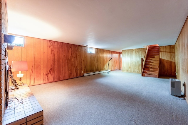 interior space featuring wooden walls, light colored carpet, and a baseboard heating unit