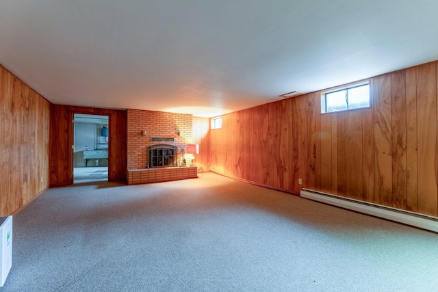 unfurnished living room with carpet floors, a fireplace, wooden walls, and a baseboard heating unit