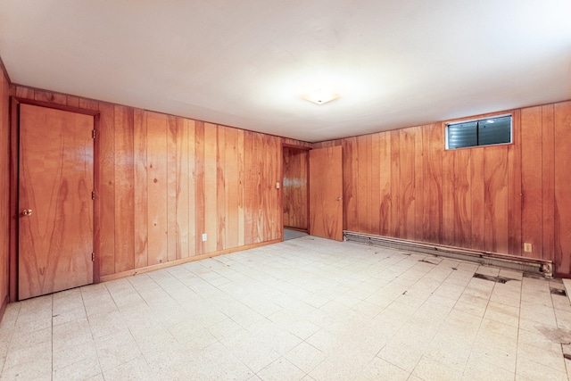 basement with baseboard heating and wooden walls