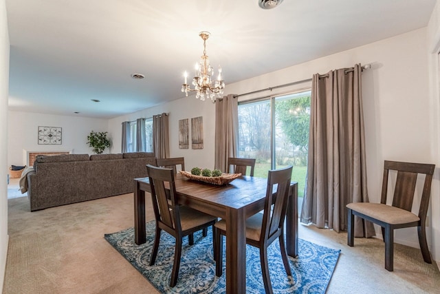 carpeted dining space featuring an inviting chandelier