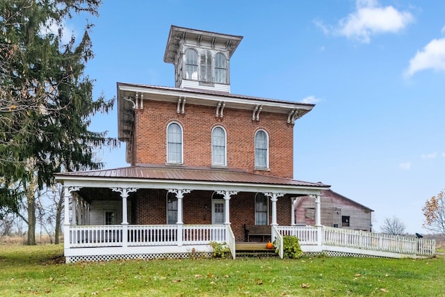 italianate-style house featuring a porch and a front yard