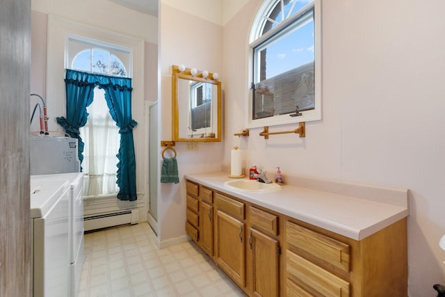 205 W Swager Dr, Fremont, IN 46737 - full bathroom featuring washing machine and clothes dryer, baseboard heating, tile patterned floors, vanity, and a shower stall