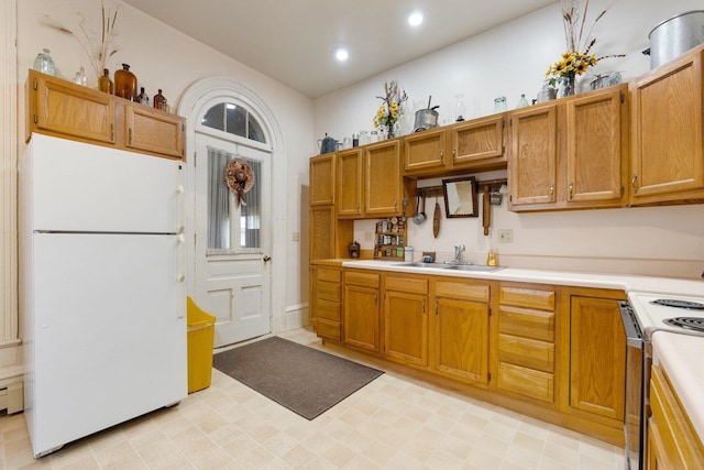 kitchen with range, white refrigerator, and sink