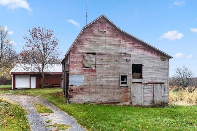 205 W Swager Dr, Fremont, IN 46737 - view of side of home featuring a barn, an outdoor structure, a lawn, a garage, and driveway