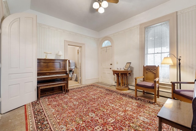 living area featuring baseboard heating and ceiling fan