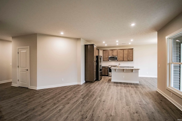 unfurnished living room with a textured ceiling and dark hardwood / wood-style floors