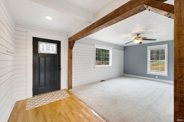 entrance foyer featuring beam ceiling, ceiling fan, and light hardwood / wood-style floors