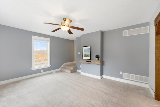 unfurnished living room with a textured ceiling, light colored carpet, and ceiling fan