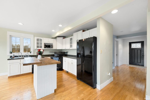 kitchen with a center island, light hardwood / wood-style flooring, and black appliances