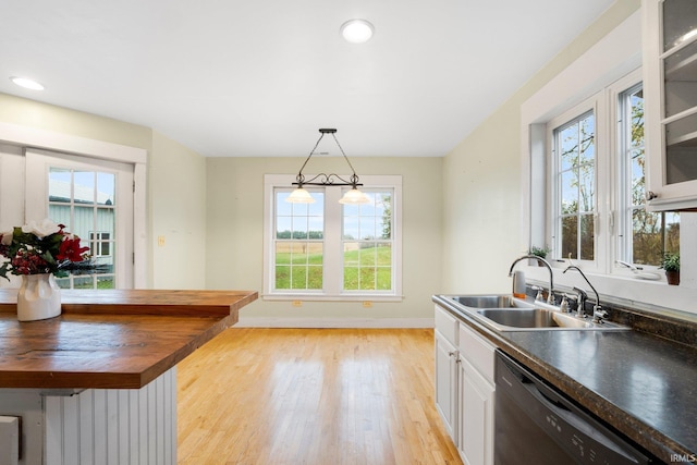 kitchen with white cabinets, stainless steel dishwasher, a wealth of natural light, and sink