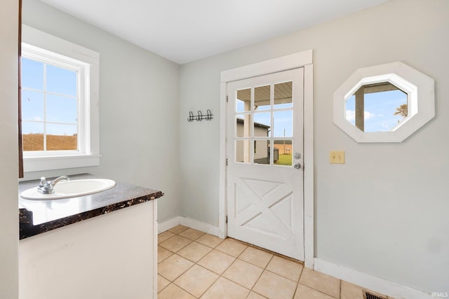 doorway featuring light tile patterned floors and sink