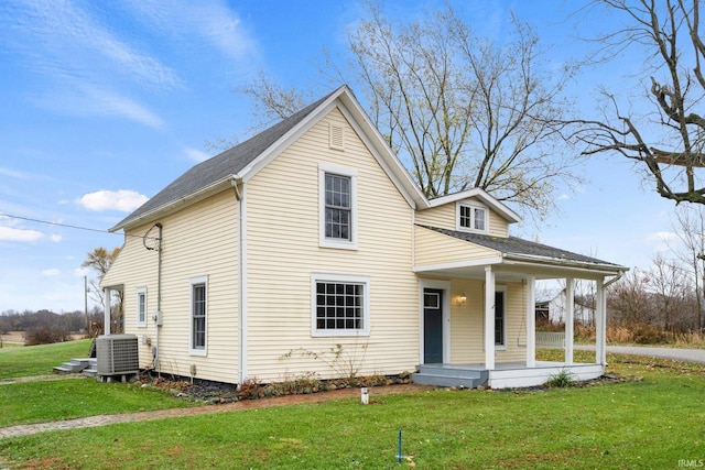 view of front of house featuring a porch, central air condition unit, and a front yard