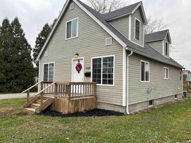 rear view of house with cooling unit and a yard