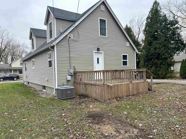 back of house featuring central air condition unit, a wooden deck, and a lawn