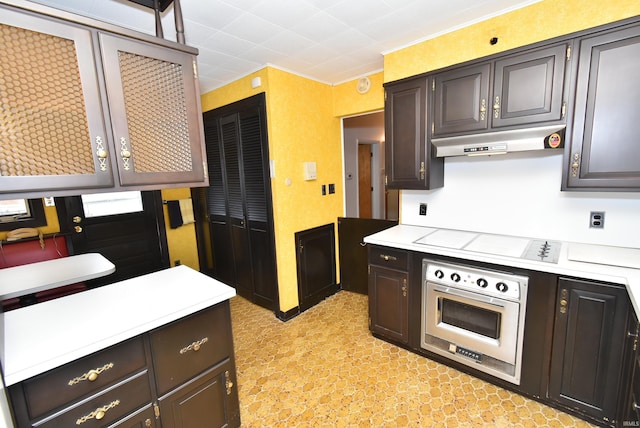 kitchen featuring wall oven, dark brown cabinetry, and cooktop