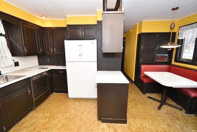 kitchen featuring dark brown cabinetry, dishwasher, sink, white fridge, and pendant lighting