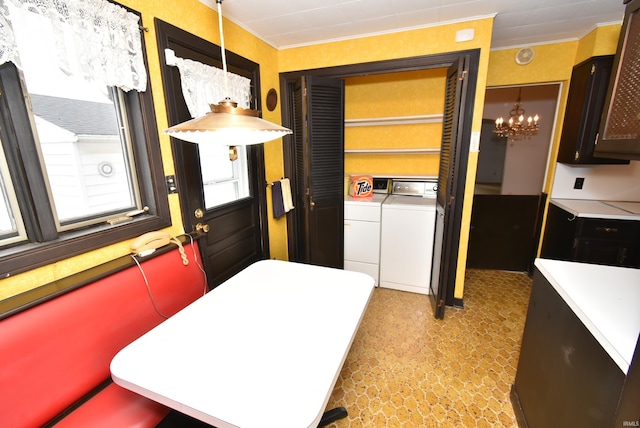 laundry room with washing machine and dryer and an inviting chandelier