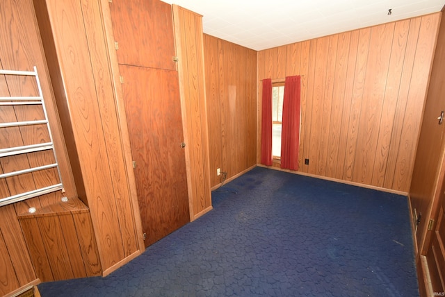 empty room with wooden walls and dark carpet