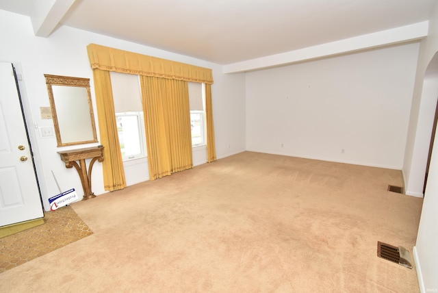 interior space with carpet and beamed ceiling