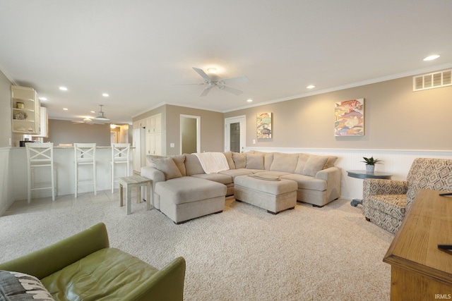 carpeted living room featuring ceiling fan and ornamental molding