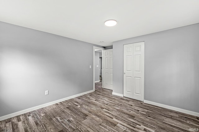 unfurnished bedroom with a closet and wood-type flooring