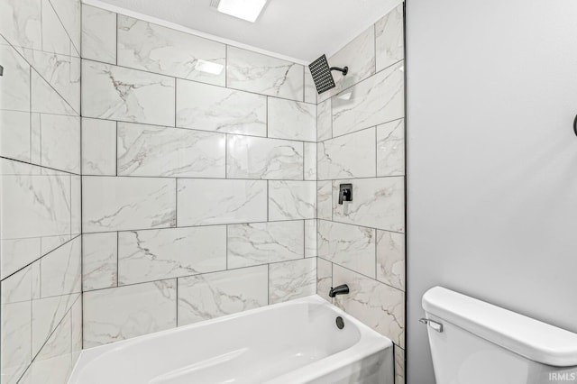 bathroom with tiled shower / bath combo and toilet