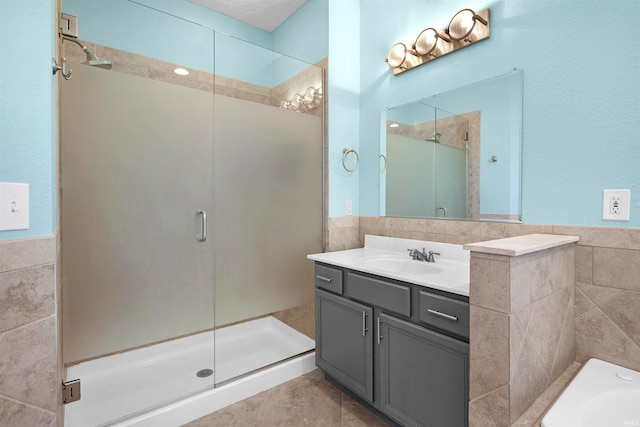 bathroom featuring vanity, an enclosed shower, and tile walls