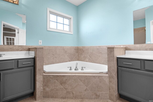 bathroom featuring vanity and a relaxing tiled tub