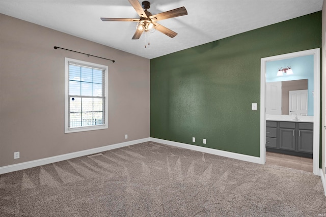 carpeted empty room featuring ceiling fan and sink