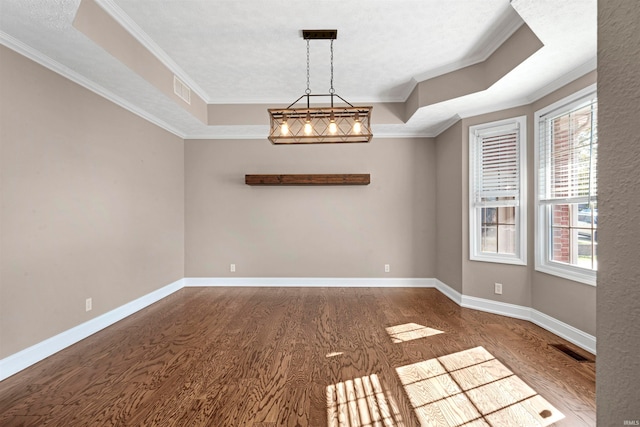 spare room with a tray ceiling, crown molding, and plenty of natural light