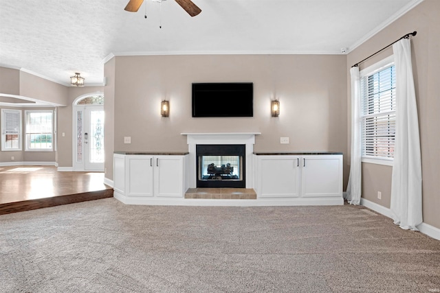 unfurnished living room with plenty of natural light, ceiling fan, and light carpet