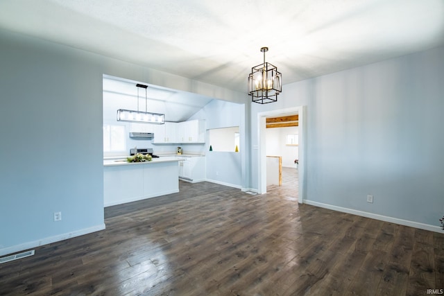 unfurnished living room with dark wood-type flooring, lofted ceiling, and a notable chandelier