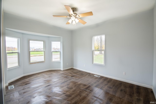 empty room with ceiling fan and dark hardwood / wood-style floors