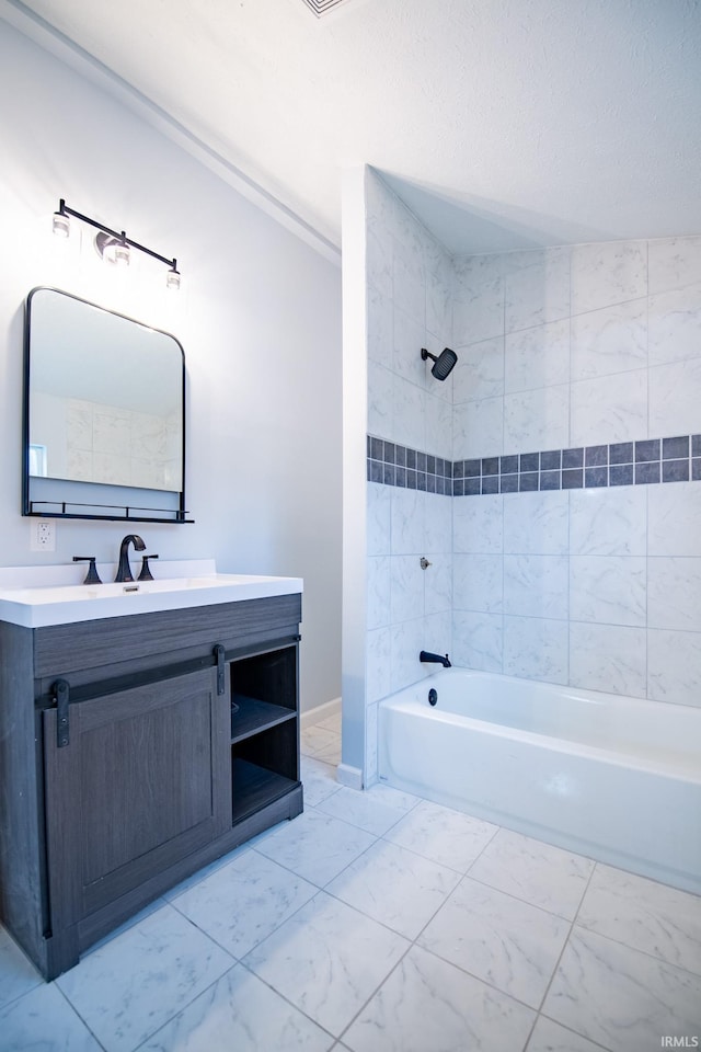 bathroom featuring vanity and tiled shower / bath