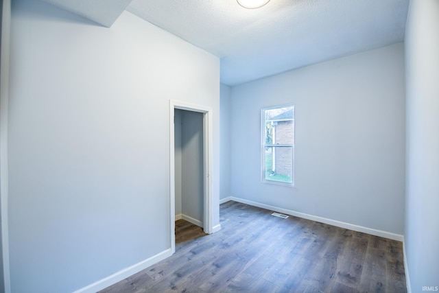 unfurnished room with dark hardwood / wood-style flooring