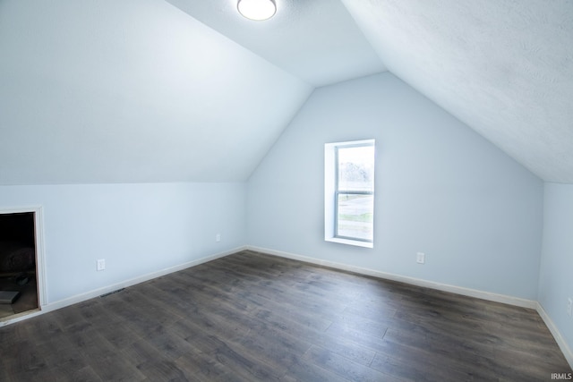 additional living space with dark hardwood / wood-style floors and lofted ceiling