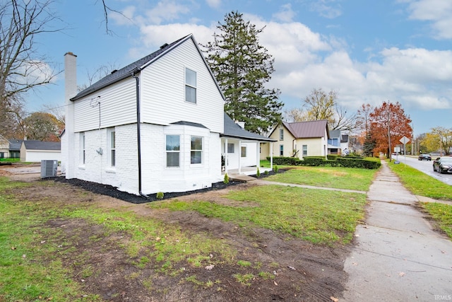 view of property exterior featuring central air condition unit and a lawn