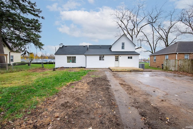 back of property with a wooden deck and a yard